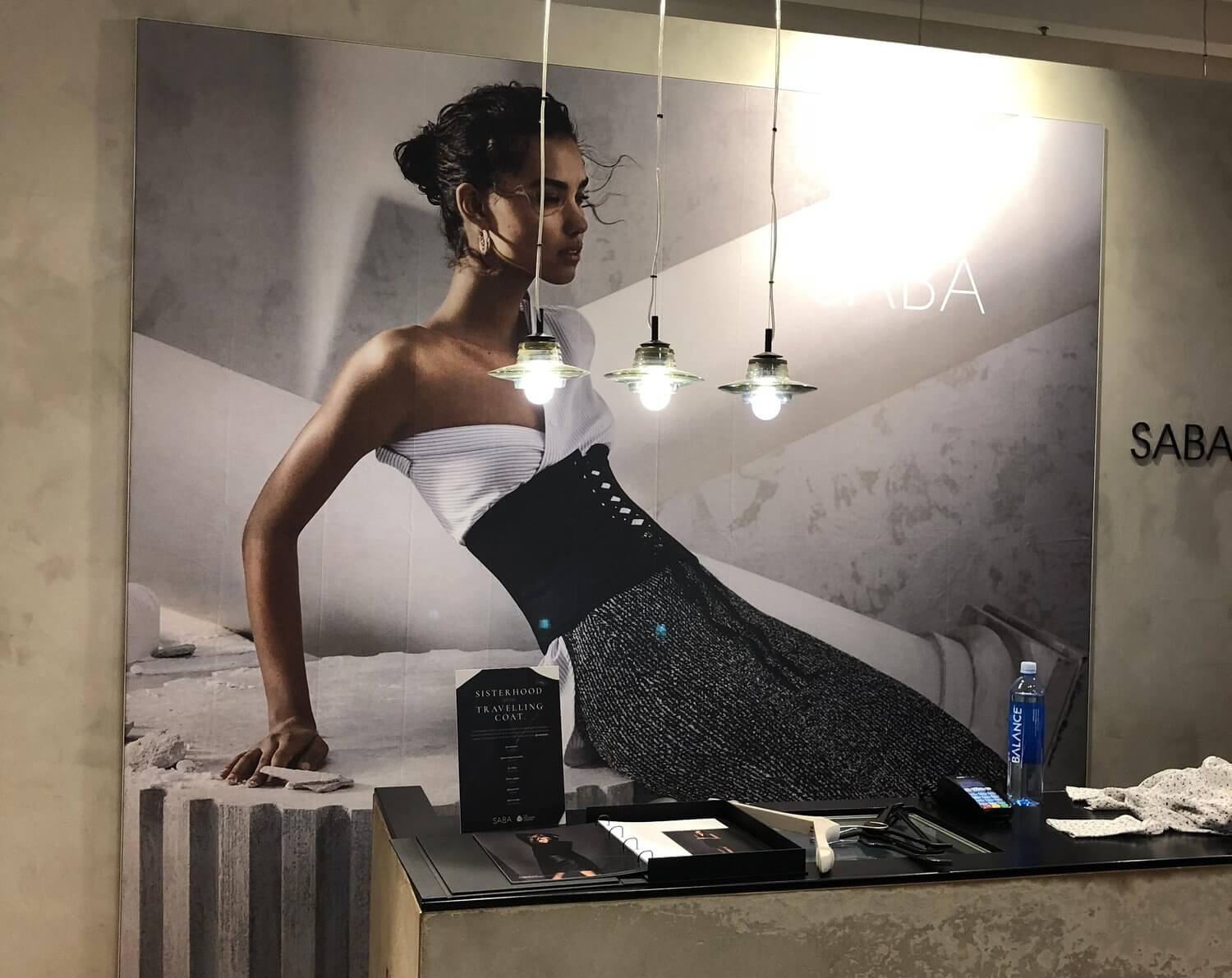 SABA in-store counter with model printed on a poster.
