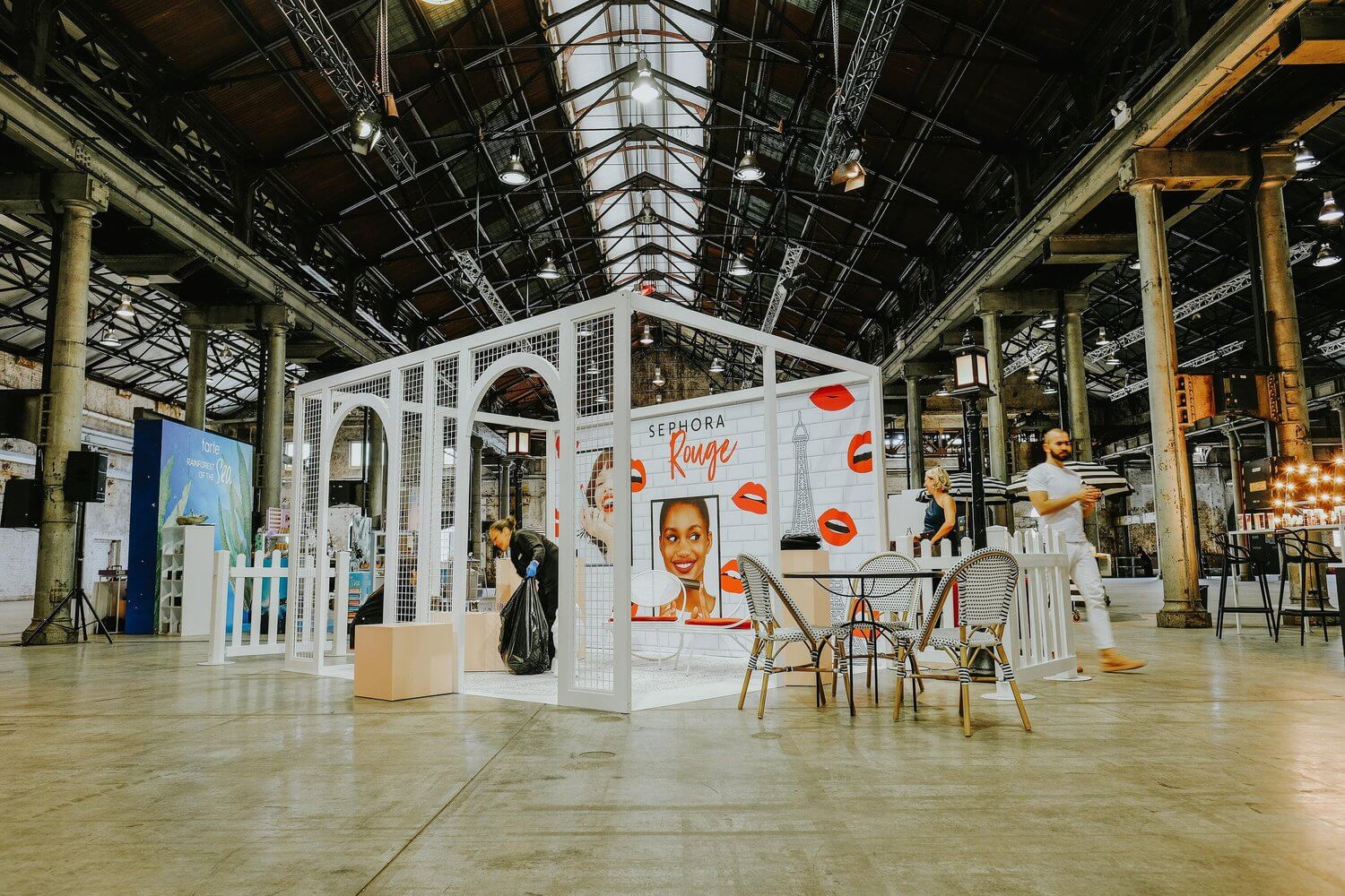 A display of the Sephora Rouge range in a large warehouse with a table and chairs in front of it.
