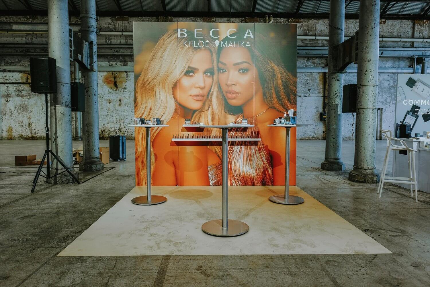 A large display with the faces of Khloe and Malika representing the BECCA Brand, where you can try on their lipstick.