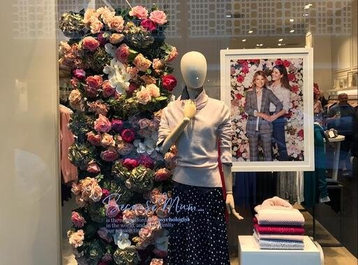 Mannequin with large column of bouquet behind it.