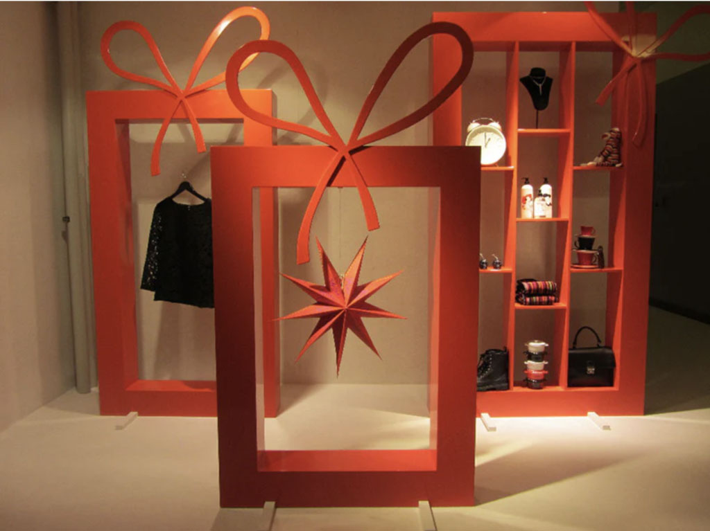 Large red Christmas box frame clothing display with a large ribbon for Athlens.